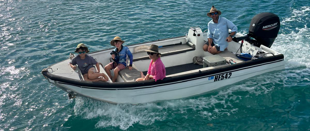 People on a small boat in the water with a Mercury outboard motor.